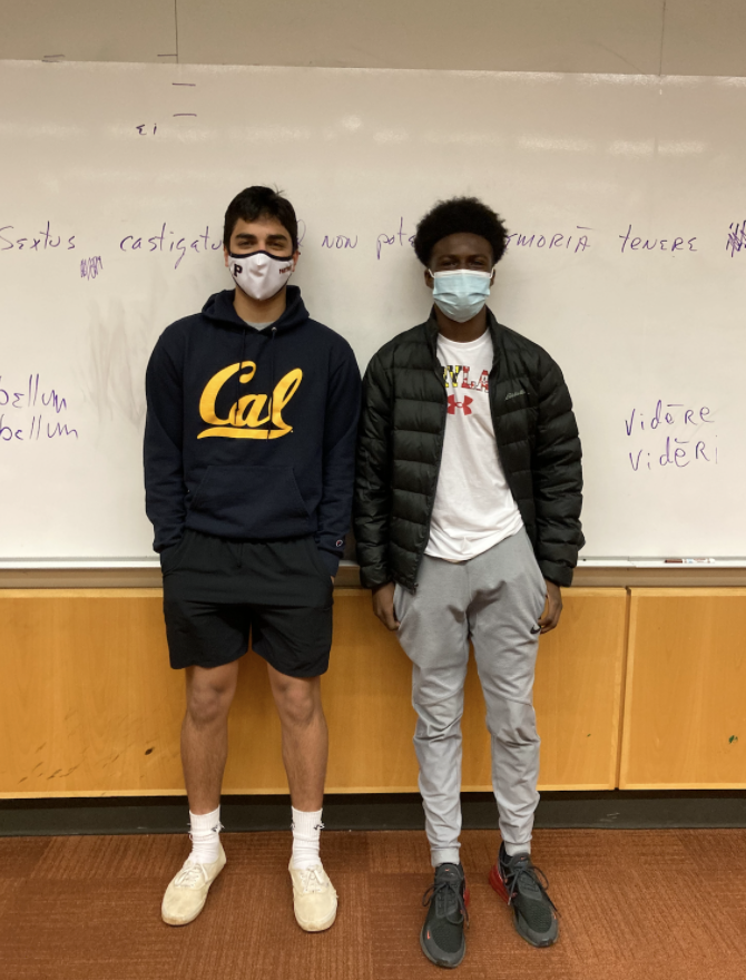 Sovan Patnaik ‘23 (left) and Malik Shelton ‘23 (right)are photographed together in the Tiered Classroom. College merchandise has proven to be a staple at Potomac. Sovan is repping the University of California, Berkeley. He has chosen to wear darker shorts to bring out the vibrant yellow “Cal” on his sweatshirt. His once white vans and quirky inside-out nike socks add brightness to his outfit. Malik is repping the University of Maryland. His outfit follows a grey-white color scale that allows the flag printed “Maryland” to stand out. His black Eddie Bauer jacket and black Nike shoes contrast well with his entire ensemble. 