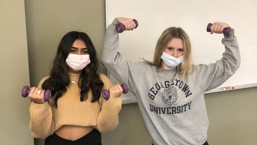 Senior debate team captains Samira Abbasi and Isabel Brittin working out with the infamous 2-pound weights.